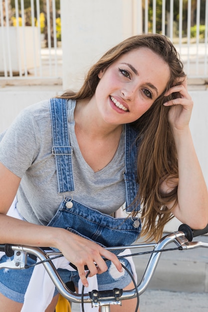 Retrato, de, um, sorrindo, mulher jovem, com, bicicleta