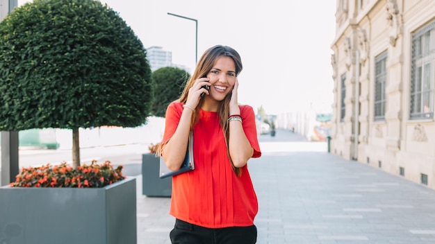 Retrato, de, um, sorrindo, mulher jovem, conversa num telemóvel