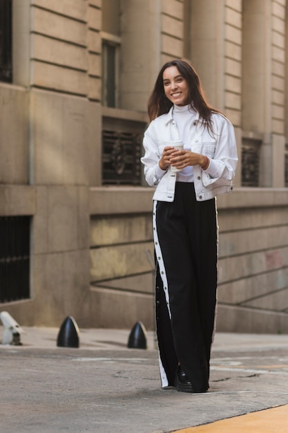 Retrato, de, um, sorrindo, mulher jovem, segurando, copo café descartável, em, mão