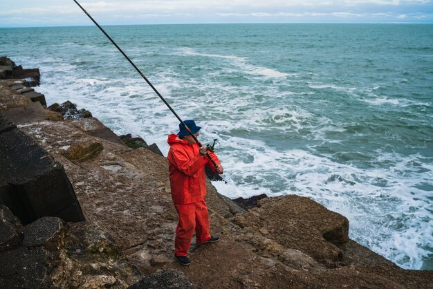 Retrato de um velho pescando no mar. Conceito de pesca.