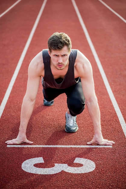 Retrato de um velocista masculino pronto para corrida na pista