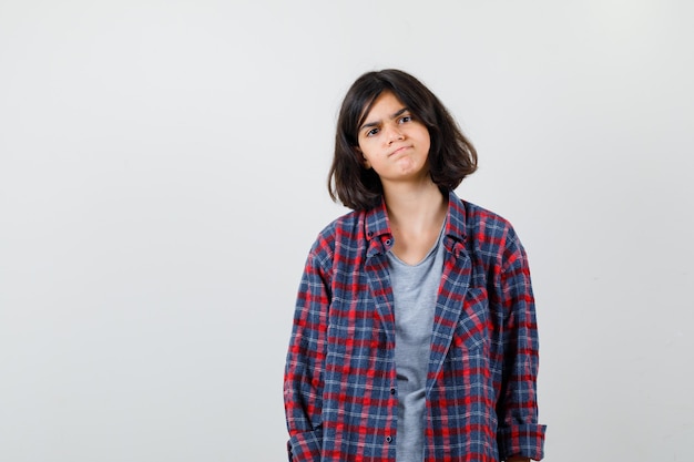 Retrato de uma adolescente com roupas casuais e uma vista frontal sombria