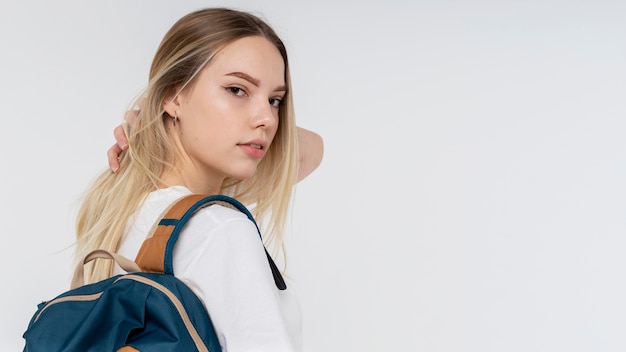 Retrato de uma adolescente segurando sua mochila e seu cabelo puxado para trás