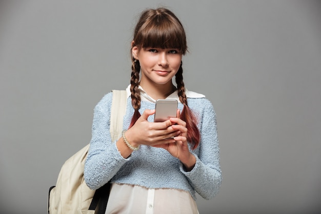 Foto grátis retrato de uma adorável colegial sorridente com mochila