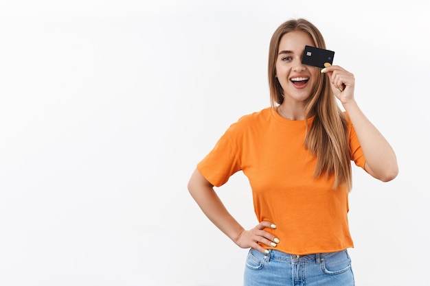 Retrato de uma alegre garota loira em uma camiseta laranja