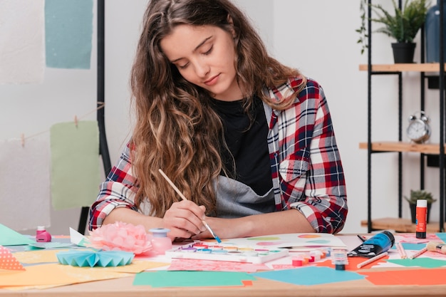 Foto grátis retrato de uma artista feminina atraente jovem, pintura em papel