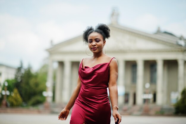 Retrato de uma bela jovem africana natural com cabelo afro Modelo negro em vestido de seda vermelho