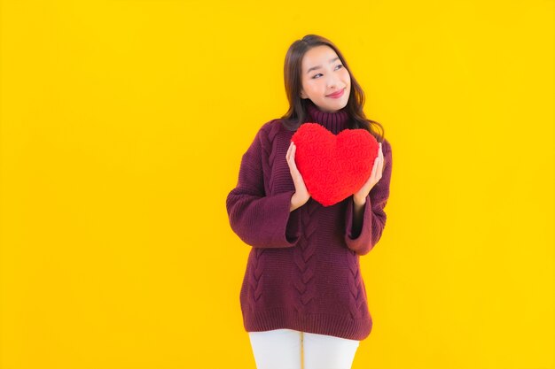 Retrato de uma bela jovem asiática com formato de almofada em forma de coração