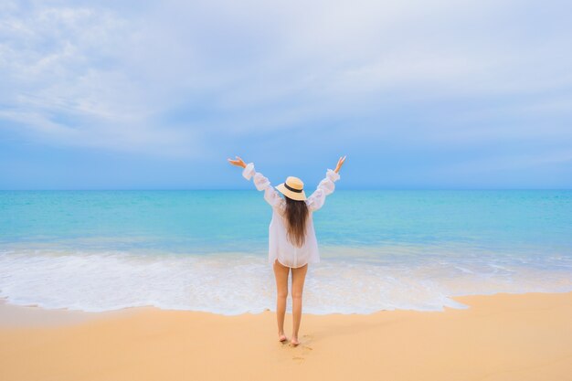 Retrato de uma bela jovem asiática relaxando ao redor da praia, mar, oceano, em viagens de férias