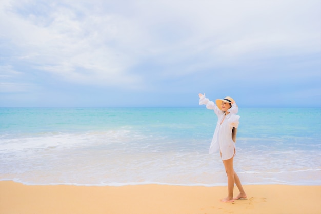 Retrato de uma bela jovem asiática relaxando ao redor da praia, mar, oceano, em viagens de férias
