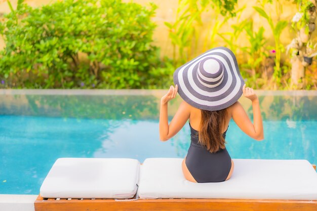 Retrato de uma bela jovem asiática relaxando na piscina