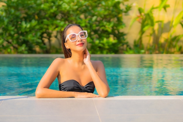 Retrato de uma bela jovem asiática relaxando na piscina