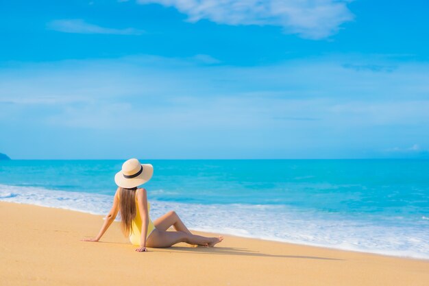 Retrato de uma bela jovem asiática relaxando na praia em viagens de férias