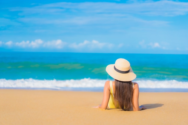 Retrato de uma bela jovem asiática relaxando na praia em viagens de férias