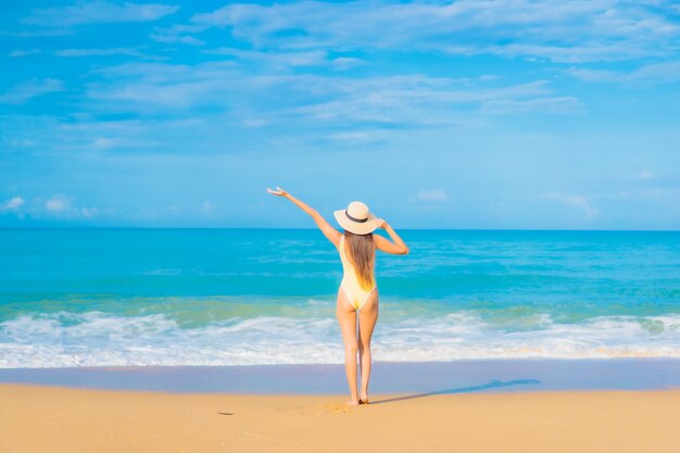 Retrato de uma bela jovem asiática relaxando na praia em viagens de férias