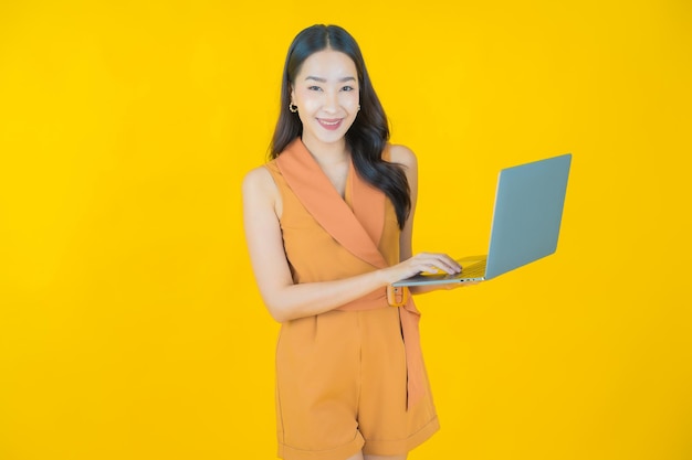 Retrato de uma bela jovem asiática sorrindo com um computador laptop