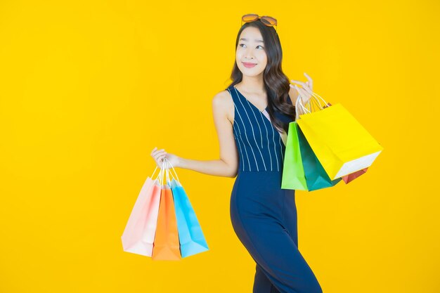 Retrato de uma bela jovem asiática sorrindo com uma sacola de compras