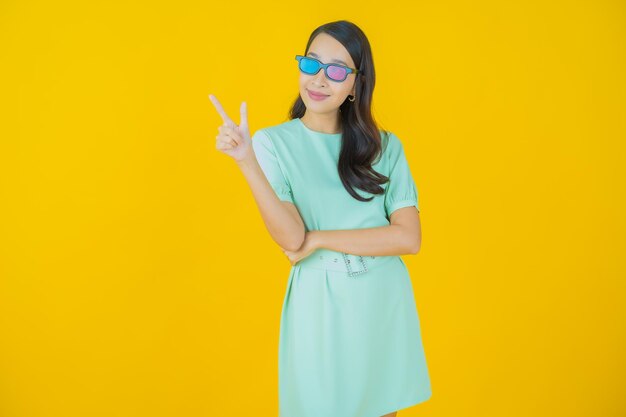 Retrato de uma bela jovem asiática usando óculos 3D com fundo de cor