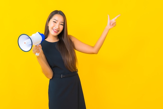 Retrato de uma bela jovem de negócios asiáticos usando megafone para comunicação