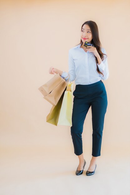 Retrato de uma bela jovem mulher asiática de negócios com muitas sacolas de compras no varejo e em loja de departamentos