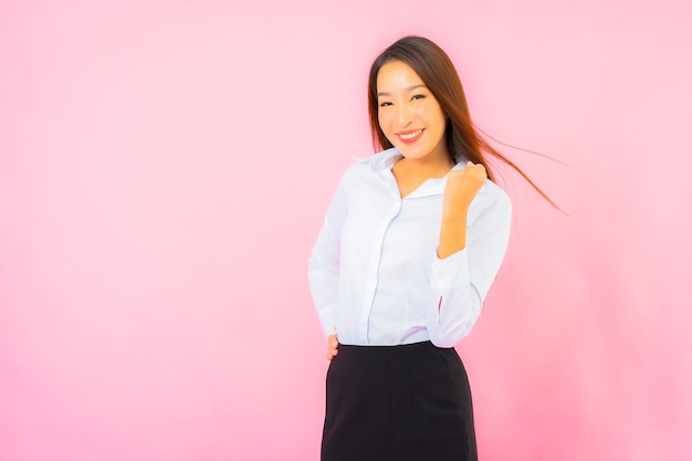 Retrato de uma bela jovem mulher asiática de negócios com parede rosa de ação isolada