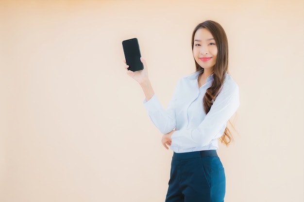 Retrato de uma bela jovem mulher asiática de negócios com telefone celular inteligente e xícara de café