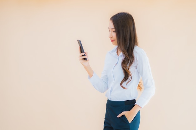 Retrato de uma bela jovem mulher asiática de negócios com telefone celular inteligente e xícara de café