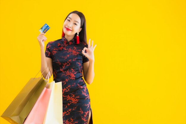 Retrato de uma bela jovem mulher asiática usa vestido chinês com sacola de compras