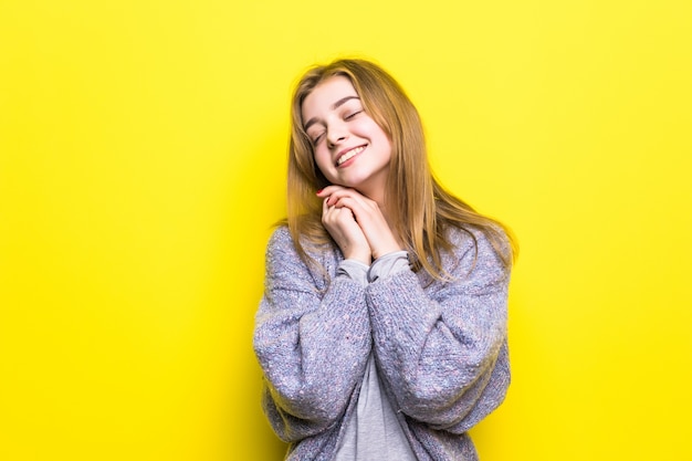 Retrato de uma bela jovem sonhadora sorrindo olhando para cima pensando sonhando com a mão no queixo.