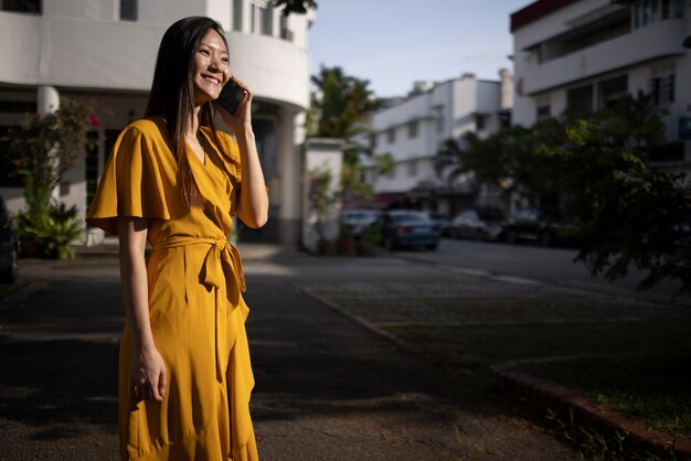 Retrato de uma bela mulher asiática usando um smartphone ao ar livre na cidade