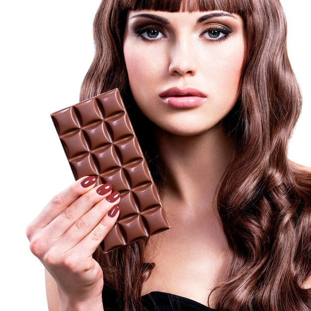 Retrato de uma bela mulher sexy com barra de chocolate - isolado no branco.