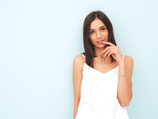 Retrato de uma bela mulher sorridente, vestida de pijama branco.