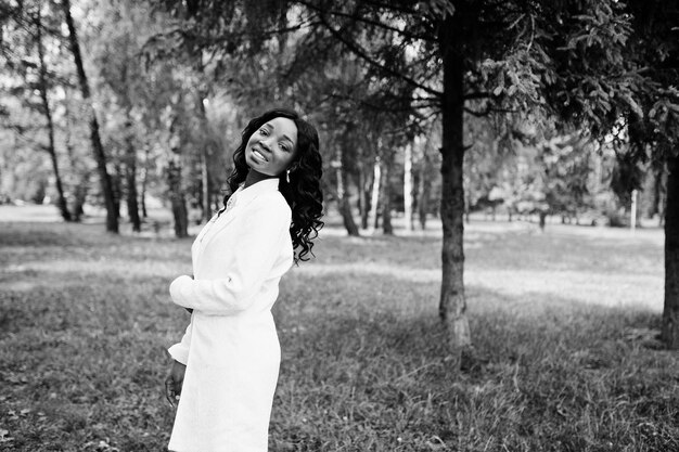 Retrato de uma elegante garota afro-americana fica no parque verde