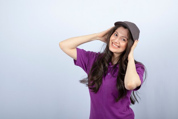 Retrato de uma garota de entrega de uniforme roxo em pé sobre fundo branco. Foto de alta qualidade