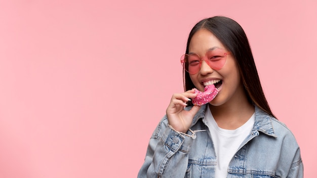 Retrato de uma jovem adolescente comendo uma rosquinha