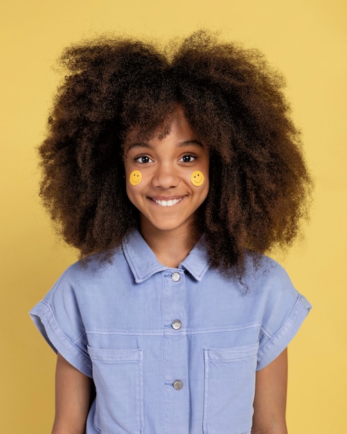 Foto grátis retrato de uma jovem adorável posando com adesivos de emoji no rosto