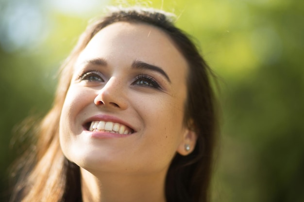 Foto grátis retrato de uma jovem atraente brilhando com felicidade, sorrindo e olhando para cima