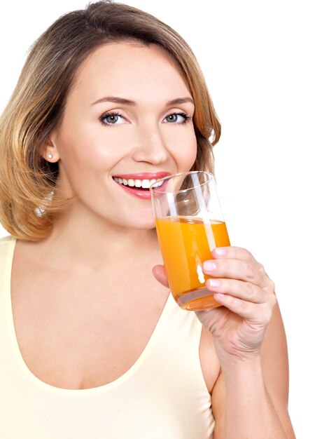 Retrato de uma jovem bonita com um copo de suco de laranja isolado no branco.