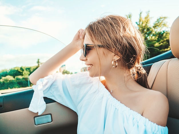 Retrato de uma jovem bonita e sorridente hippie em um carro conversível