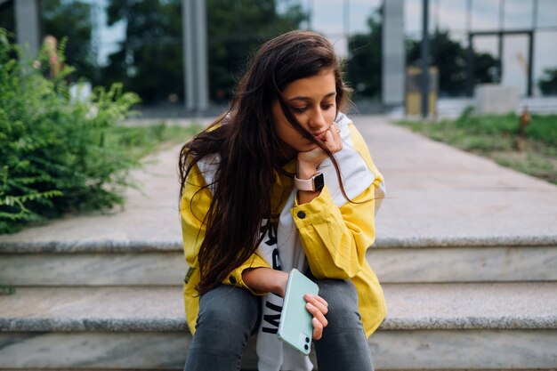 Retrato de uma jovem bonita se divertindo e posando ao ar livre.