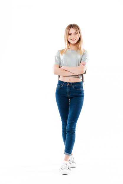 Retrato de uma jovem casual de pé com as mãos postas