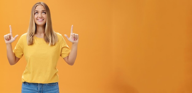 Foto grátis retrato de uma jovem caucasiana alegre e alegre com cabelo castanho e branco olhando e apontando