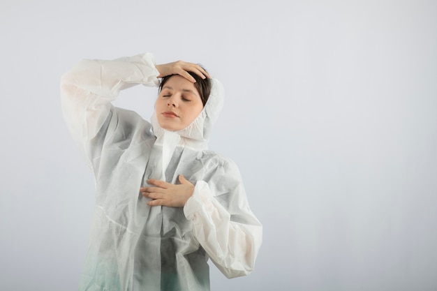 Retrato de uma jovem cientista médica posando de jaleco defensivo.