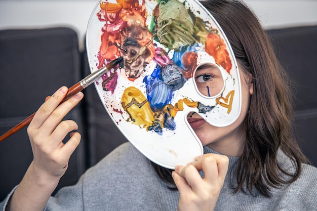 Foto grátis retrato de uma jovem com uma paleta de tintas