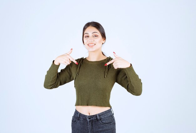 Foto grátis retrato de uma jovem e bela modelo apontando para o lado inferior