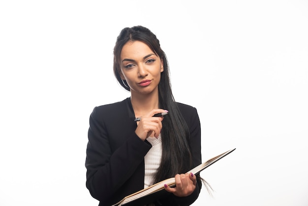 Retrato de uma jovem empresária segurando um caderno com uma caneta