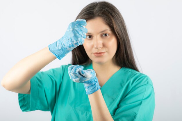 Retrato de uma jovem enfermeira ou médico em uniforme verde posando.