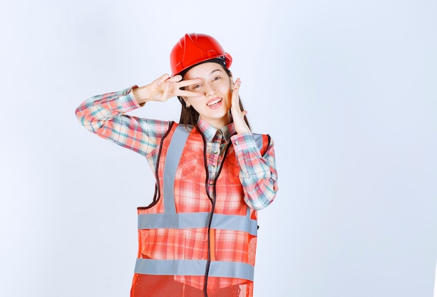 Retrato de uma jovem engenheira no capacete, sorrindo para a câmera.