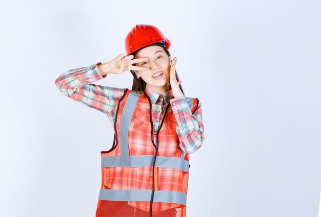 Retrato de uma jovem engenheira no capacete, sorrindo para a câmera.