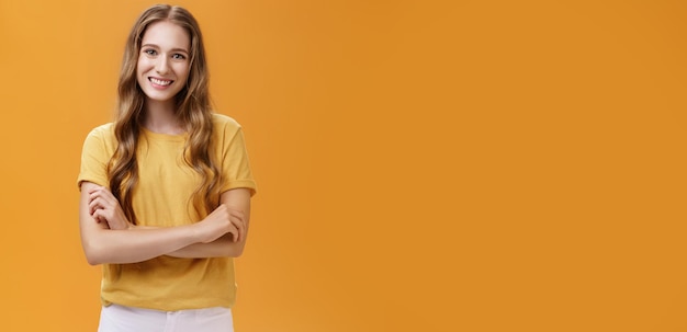 Foto grátis retrato de uma jovem estudante amável e simpática em camiseta casual com comprimento natural ondulado